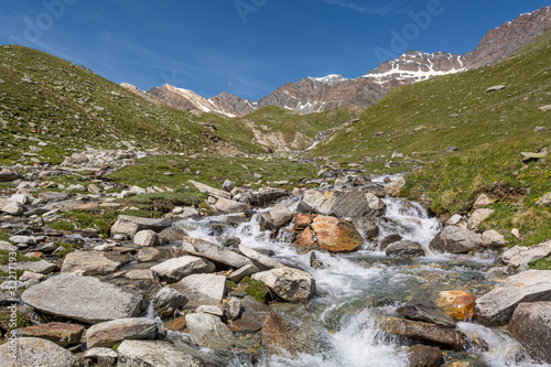 Glacier water spilling across mountain valley forming many streams.