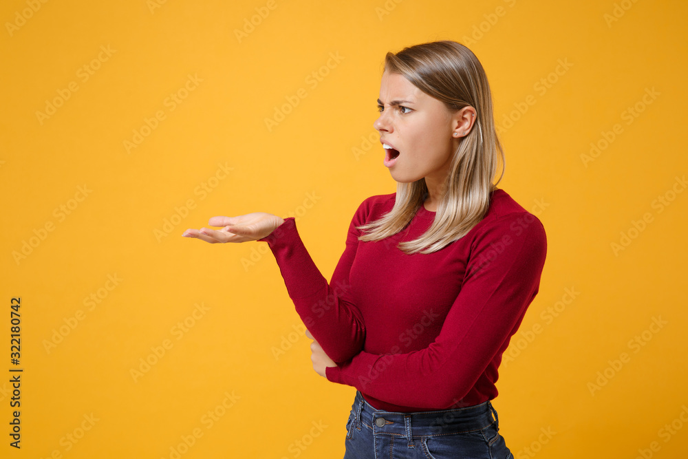 Shocked bewildered young blonde woman girl in casual clothes posing isolated on yellow orange background studio portrait. People lifestyle concept. Mock up copy space. Spreading hand, looking aside. Shocked bewildered young blonde woman girl in casual clothes posing isolated on yellow orange background studio portrait. People lifestyle concept. Mock up copy space. Spreading hand, looking aside.