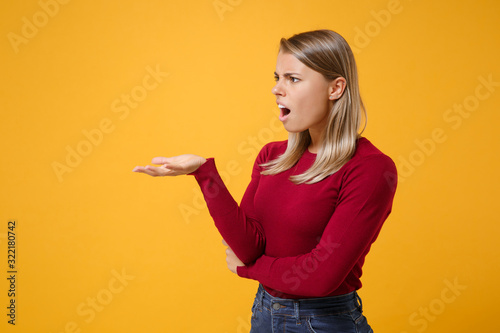 Billede på lærred Shocked bewildered young blonde woman girl in casual clothes posing isolated on yellow orange background studio portrait