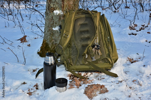 Backpack in the winter. Thermos with tea