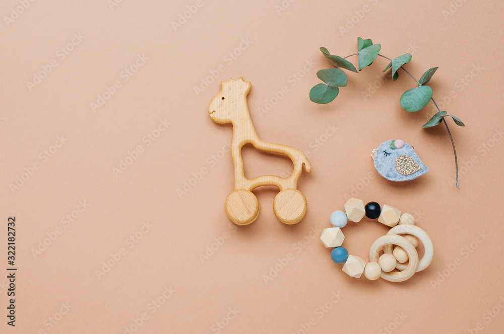 Wooden toys giraffe and teether on beige background