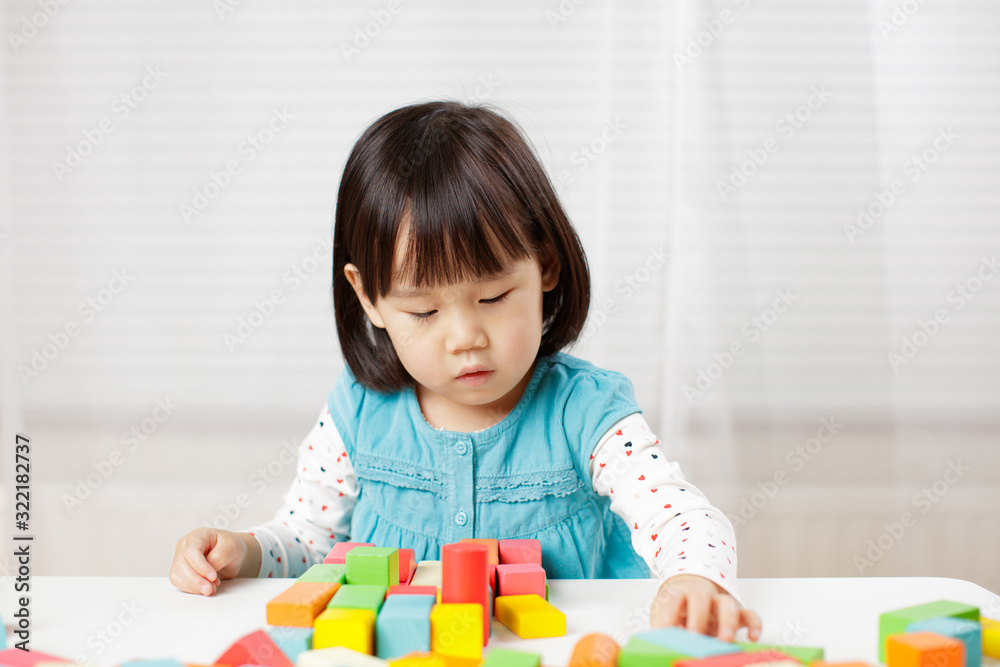 toddler girl playing creative toy blocks at home against white background toddler girl playing creative toy blocks at home against white background