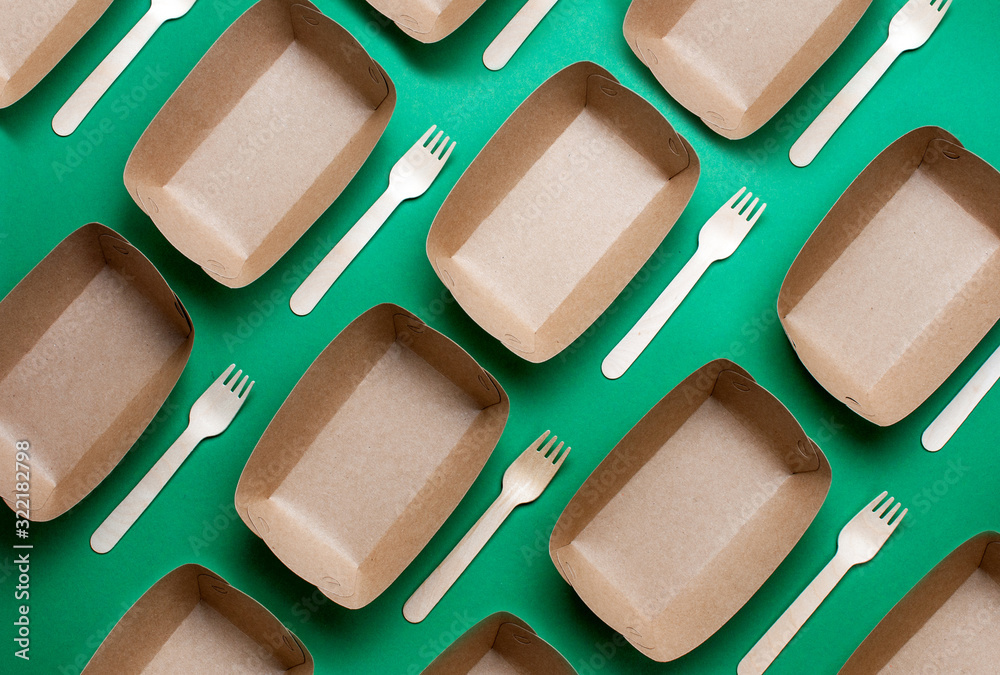 Fototapeta premium Brown kraft paper food containers on green background