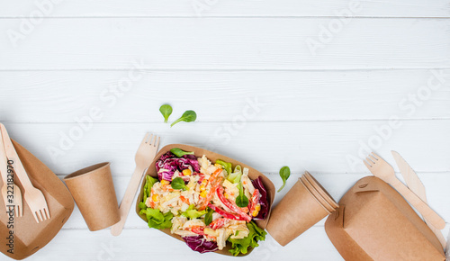 Vegetable salad in the kraft paper food containers on white background with copy space