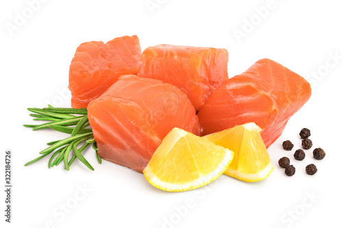 raw salmon piece cube with rosemary, lemon and peppercorn isolated on white background close up