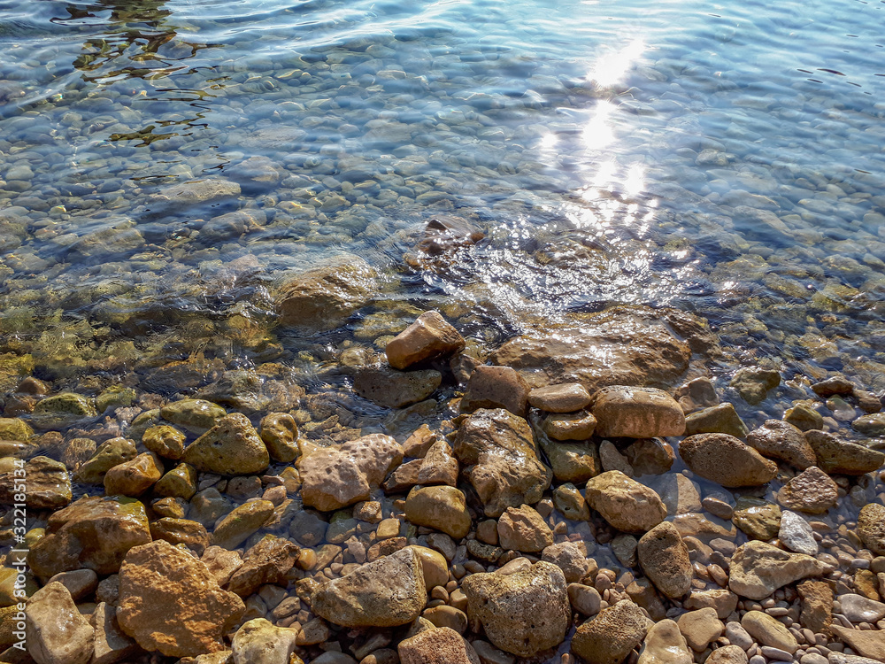 stones in turquoise sea water in Krk, Croatia