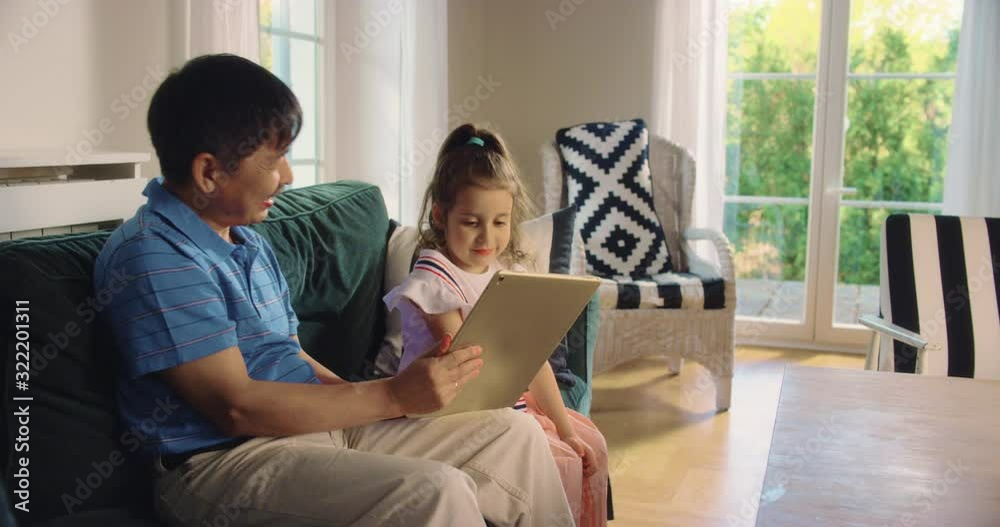 LS Granddad Using Tablet with Granddaughter. Shot in R3D (6K RED RAW) LS Granddad Using Tablet with Granddaughter. Shot in R3D (6K RED RAW)