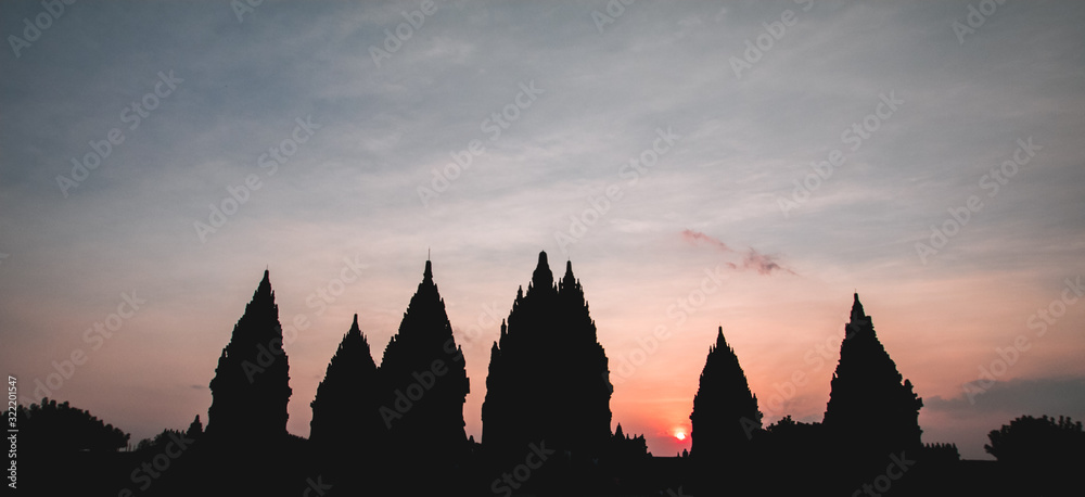 Obraz premium Prambanan or Candi Rara Jonggrang at sunset (low key). Hindu temple compound in Java, Indonesia, dedicated to the Trimurti: the Creator (Brahma), the Preserver (Vishnu) and the Destroyer (Shiva)