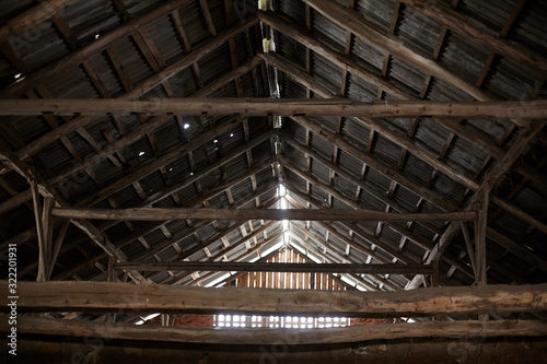 Old roof trusses covered with ceramic tile on a detached house under construction, visible roof elements, battens, counter battens, rafters. Roof system with wooden timber, beams