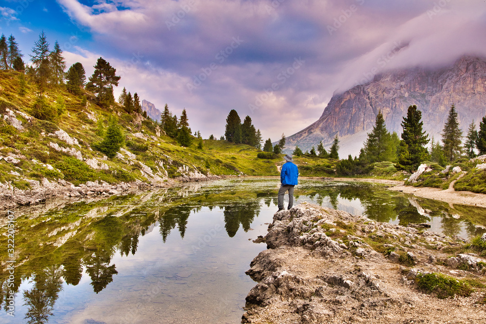 Man traveler traveling alone in breathtaking landscape of Dolomites. Amazing morning view of Limides lake. Splendid summer scene of Dolomiti Alps, Cortina d'Ampezzo, Falzarego pass, Italy, Europe.
