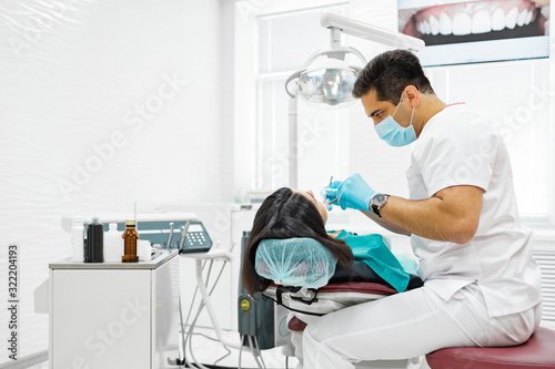 Cute young girl is being examined by the dentist