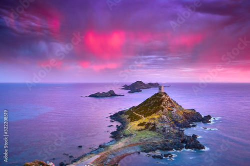 View of Pointe de la Parata on the west coast of Corsica France Europe. A ruined Genoese tower sits on top of the rocky promontory overlooking the archipelago of the Sanguinaires on the colored sunset photo
