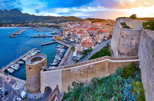 Foto View from the walls of the citadel of Calvi on the old town with historic buildings at evening sunset