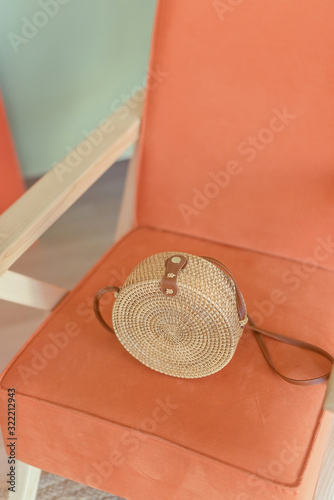 Wicker handmade bag on the armchair. Concept of the vacation