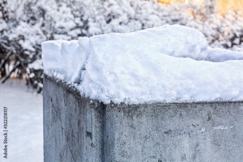 Old cement urn covered with white fluffy snow in city square Old cement urn covered with white fluffy snow in city square