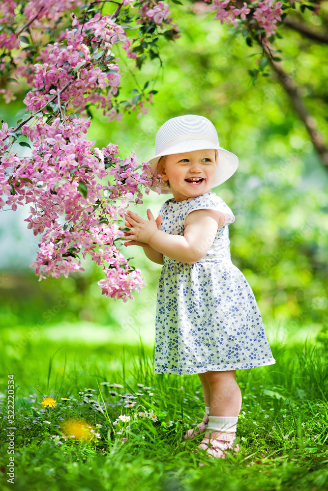 little happy girl in a blooming garden little happy girl in a blooming garden