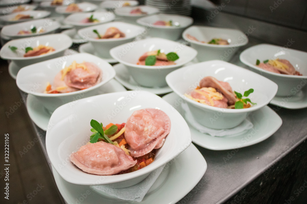 Pink ravioli with basil and tomato on plates Pink ravioli with basil and tomato on plates