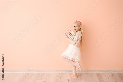 Little girl with books near...