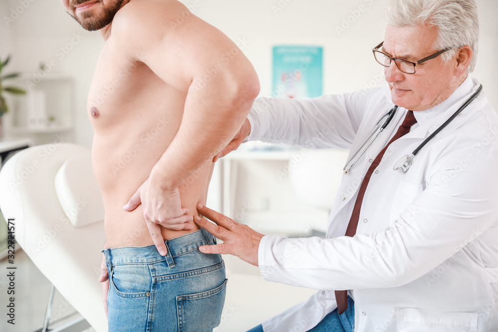 Urologist examining young patient in clinic Urologist examining young patient in clinic