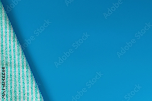 Soft terry cotton towel on a blue background. Bath towel. Personal hygiene items..