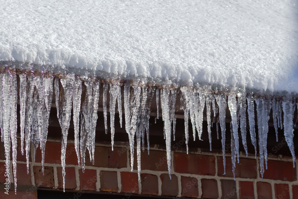 Ice icicles hanging from a roof gutter Ice icicles hanging from a roof gutter