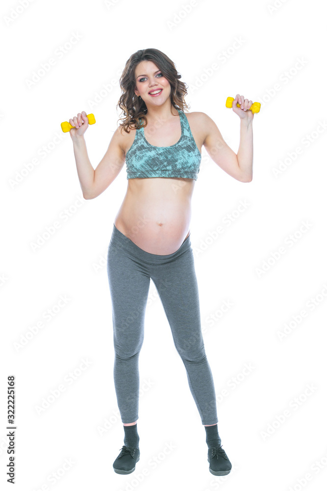 Pregnant woman training with dumbbells to stay active. Pregnant woman practicing fitness and working out during pregnancy Slim pregnant woman is engaged in fitness. Isolated white background. Pregnant woman training with dumbbells to stay active. Pregnant woman practicing fitness and working out during pregnancy Slim pregnant woman is engaged in fitness. Isolated white background.