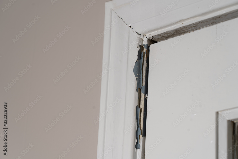 Φωτογραφία Cracked and peeling paint surround an interior door showing signs of wear and a need for repair