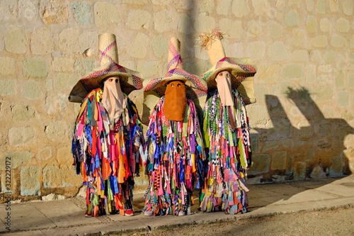 Three traditional Tiliche costume against wall in Oaxaca, Mexico photo