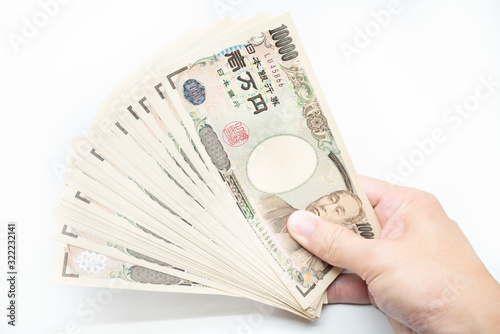 大量の1万円札を見せびらかすイメージ。白背景。シリアルナンバー加工済み。