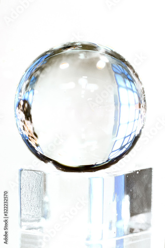 One glass ball on glass cube on white background