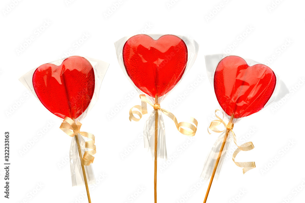 Lollipop. Three  red heart-shaped  lollipops  in transparent packaging on a white isolated background for Valentine's Day. Isolate.