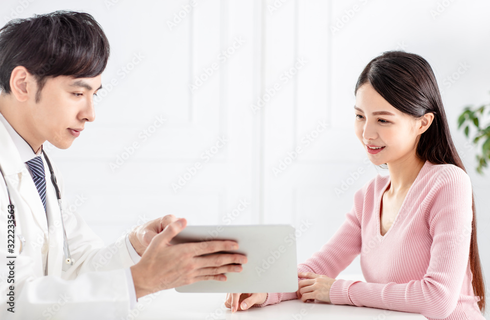 doctor showing medical reports on tablet to his patient doctor showing medical reports on tablet to his patient