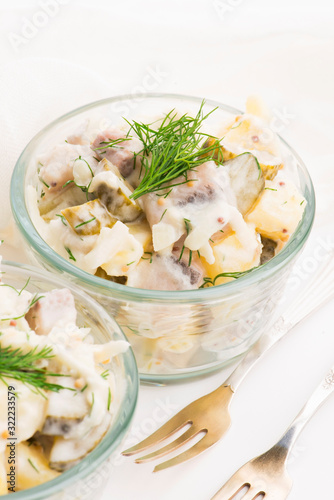 Salad rasols made of herring, cucumber and potato, dressed with mayonnaise and mustard photo