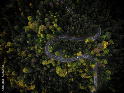 Curvy mountain road winding through a colorful forest in autumn in Bavaria, Germany