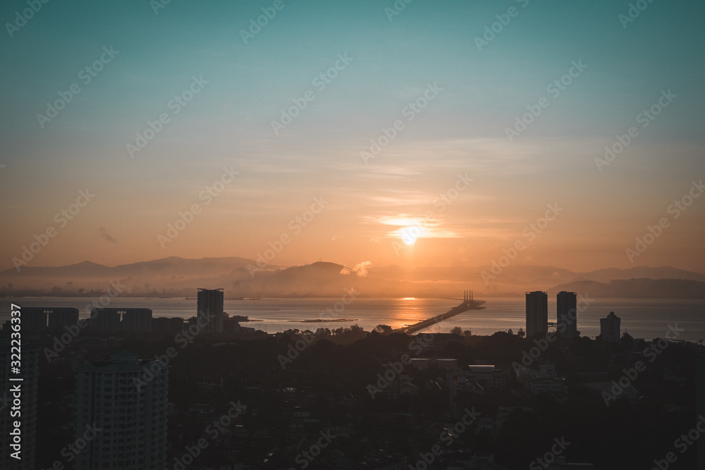 Sunrise over the Penang bridge and buildings around it