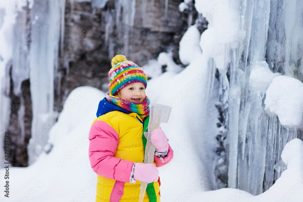 Children play with icicle in snow. Kids winter fun Children play with icicle in snow. Kids winter fun