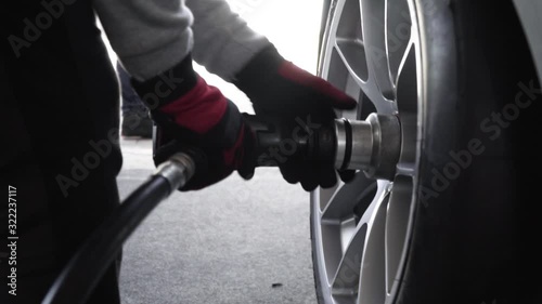 the gunner tightens the wheel nuts pit stop changing wheel in slow motion