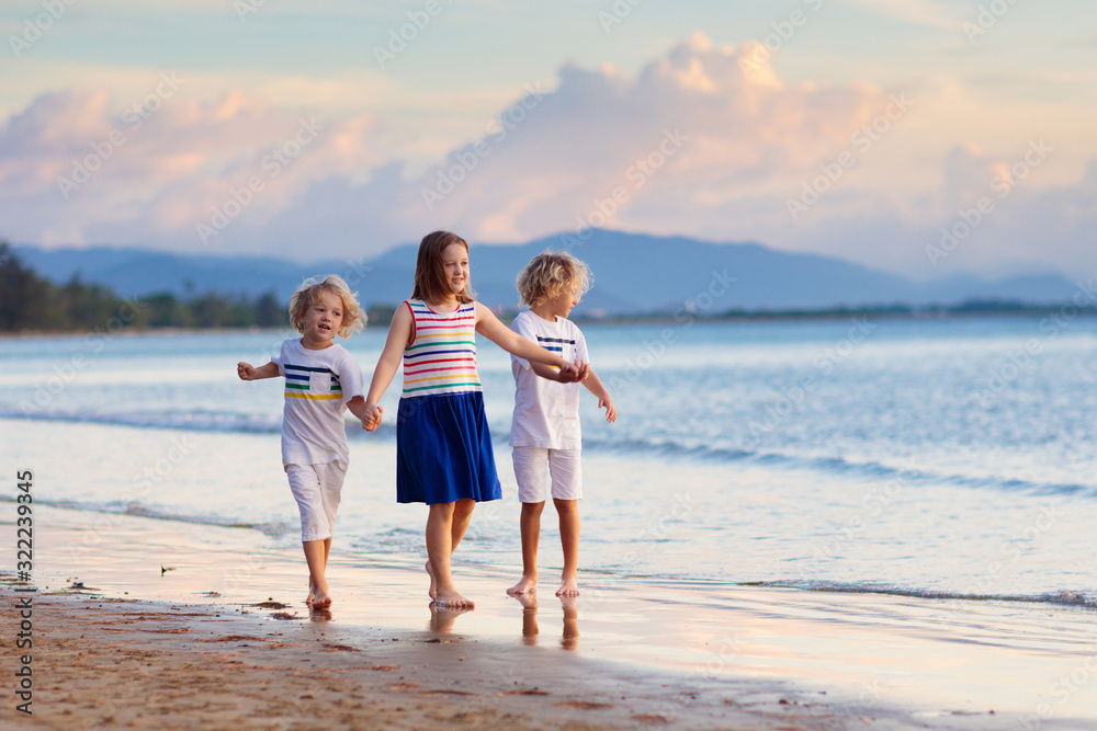 Kids play on tropical beach. Sand and water toy.