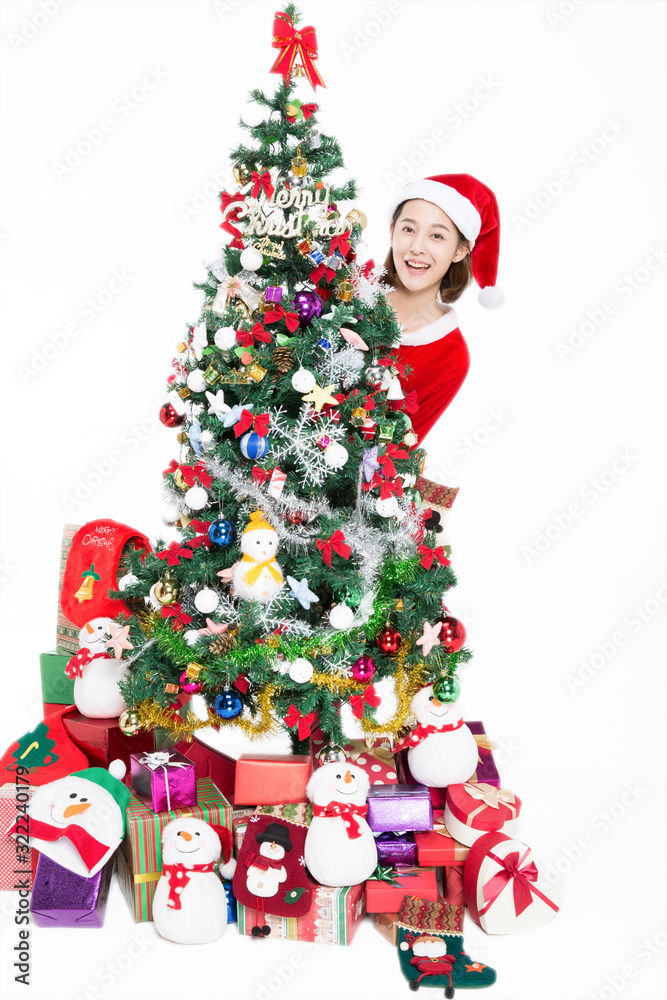 Pretty girl standing by christmas tree on white background,studio shot.There has blank space for text.