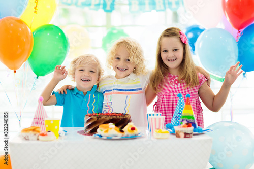 Kids birthday party. Child blowing out cake candle