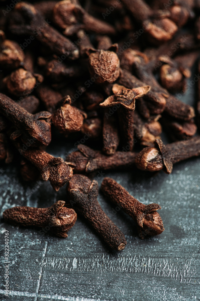 Dry cloves spices on the dark rustic background. Selective focus. shallow depth of field. Dry cloves spices on the dark rustic background. Selective focus. shallow depth of field.