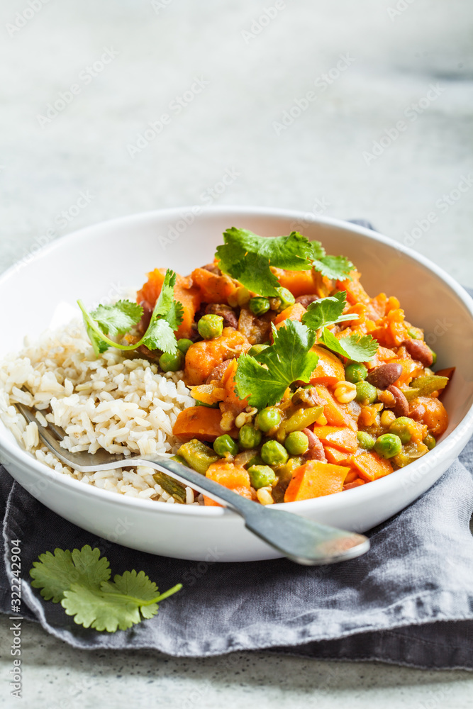 Vegan curry with rice in white bowl. Curry with sweet potato, peas and beans in a plate with rice. Vegan curry with rice in white bowl. Curry with sweet potato, peas and beans in a plate with rice.
