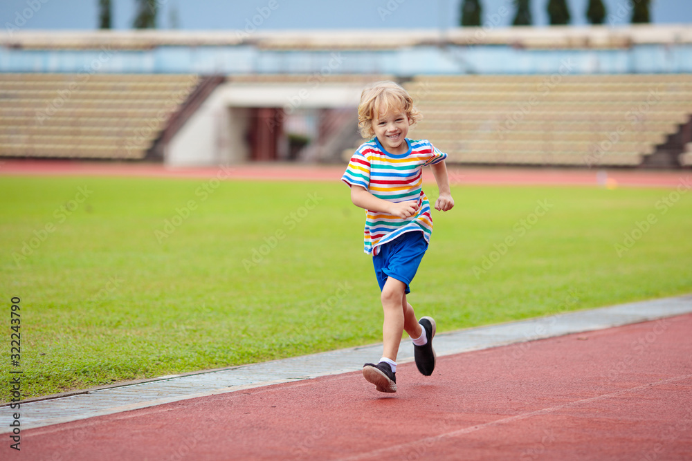 Child running in stadium. Kids run. Healthy sport.