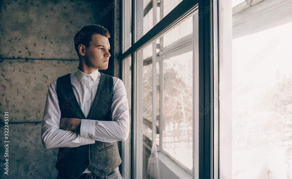 The photo of a beautiful man who is looking through the window and thinking about something big and innovative The photo of a beautiful man who is looking through the window and thinking about something big and innovative