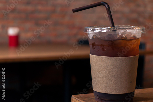 Close up of take away plastic cup of iced black coffee