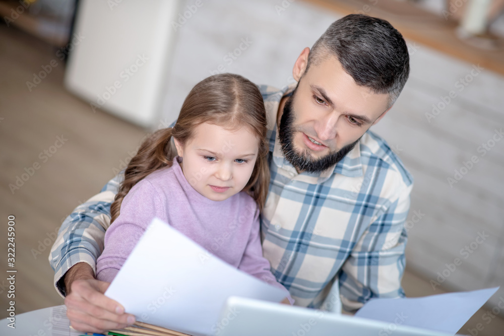 Serious dad with a daughter in her arms, with documents. Serious dad with a daughter in her arms, with documents.