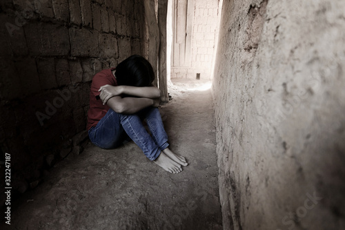 young girl sitting alone in old room. Stressed young girl. concept for bullying, depression stress or frustration. © AungMyo