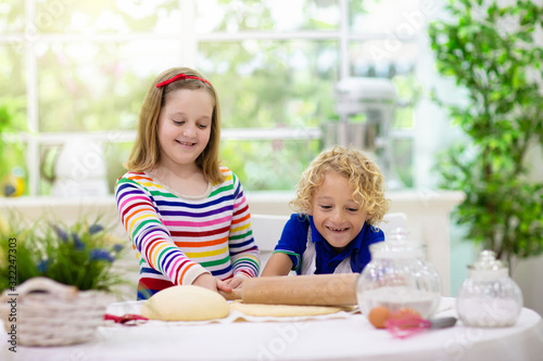 Kids baking. Children cooking in white kitchen.