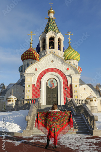 Russian tourist girl in vintage Pavlovo Posad shawl, look. Orthodox Saint Igor Chernigovsky's church in Novo-Peredelkino, Moscow city, Russia. Russian traditional national folk, retro style in fashion photo