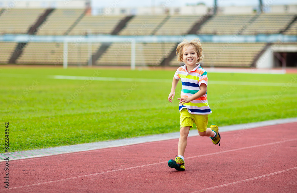 Fototapeta premium Child running in stadium. Kids run. Healthy sport.